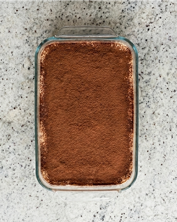 Rectangular container with brown powder on a gray speckled surface